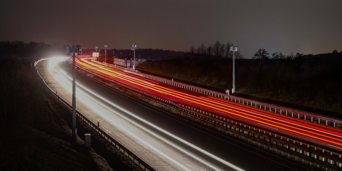 Aufnahme einer Autobahn bei Nacht, durch Langzeitbelichtung erzeugen die Scheinwerfer der Autos einen Lichtstreifeneffekt