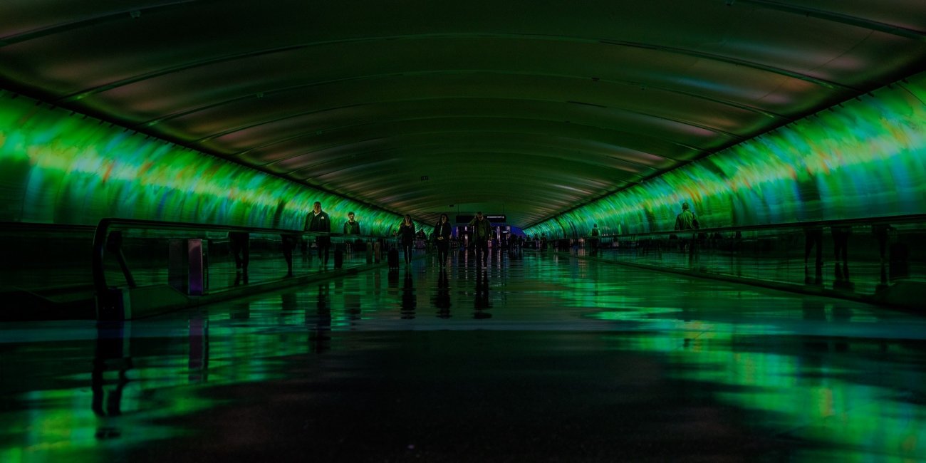 Menschen in grün erleuchtetem Tunnel