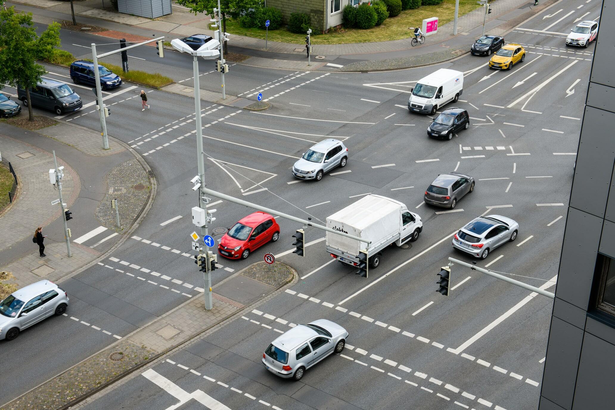 Fahrzeuge auf einer Kreuzung, die mit Road-Side-Units und Verkehrskameras ausgestattet ist