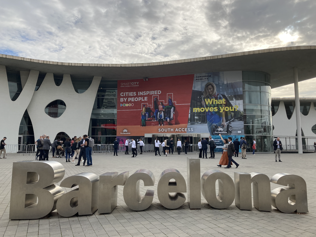 Große Kongresshalle, Menschen laufen auf den Eingang zu im Vordergrund stehen große Buchstaben auf dem Boden, die das Wort Barcelona bilden