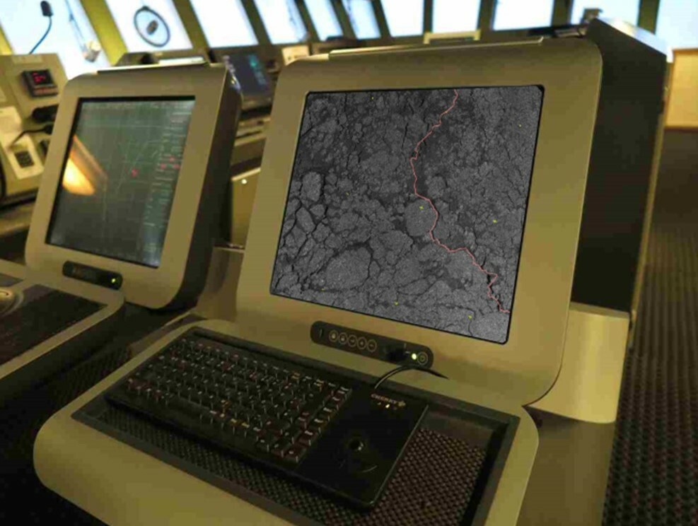Zwei Bildschirme an Bord des Forschungsschiffes Polarstern. Auf einem Monitor ist ein Satellitenbild des Polarmeeres zu sehen, darin eine rot markierte Route durch die Eisschollen